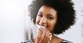 Early morning routines. Portrait of a cheerful young woman brushing her teeth while looking at her reflexion in the