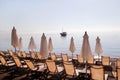 Early morning on sandy beach without people with empty chaise lounges, sun beds, sunshades, summer umbrella parasol, loungers. Royalty Free Stock Photo