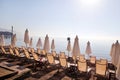 Early morning on sandy beach without people with empty chaise lounges, sun beds, sunshades, summer umbrella parasol, loungers. Royalty Free Stock Photo