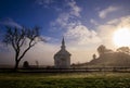 Early morning sun, mist, and fog on small rural church in field Royalty Free Stock Photo