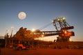 Beautiful isolated massive iron ore reclaimer industry mining heavy duty equipment machinery with full moon