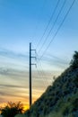 Early morning sunrise below the hills of nature and power line towers used for communication and energy transportation Royalty Free Stock Photo