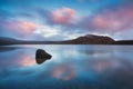 Early morning sunrise, landscape scenery of blue lake, wild mountains and huge volcano, autumn colours and golden sun rays.