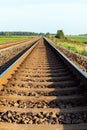 Early morning sunrise over a green field and empty railroad tracks Royalty Free Stock Photo