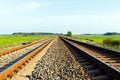 Early morning sunrise over a green field and empty railroad tracks Royalty Free Stock Photo