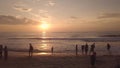 Early morning sunrise in sky on summer beach aerial view. Peoople watching morning dawn in golden sky on sandy beach