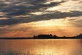 Early morning sunrise with sunrays poking through clouds over Rend Lake in Illinois