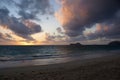 Early Morning Sunrise on Waimanalo Beach over ocean bursting through the clouds Royalty Free Stock Photo