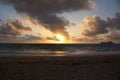 Early Morning Sunrise on Waimanalo Beach over ocean bursting through the clouds Royalty Free Stock Photo