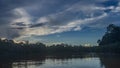 Early morning in the tropics. A calm river with banks overgrown with rain forest trees Royalty Free Stock Photo