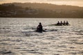 Early morning view on the river Derwent in Hobart of a a single sculler and coxless four rowers training