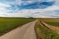 Early psirngtime countryside with road, fields, wind turbines and blue sky with clouds