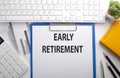 EARLY RETIREMENT written on paper with keyboard, chart, calculator and notebook Royalty Free Stock Photo