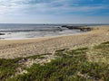 Early spring day on the beach at Povoa de Varzim, Portugal with blue sky and thin wispy white clouds.