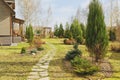 early spring garden view with stone pathway and wooden house Royalty Free Stock Photo