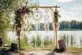 In early spring, a lakeside wedding arch is decorated in boho style with dream catchers Royalty Free Stock Photo