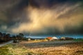 Early spring landscape with dramatic sky, rainbow and buildings Royalty Free Stock Photo