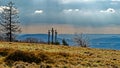 Glistening meadow and sunrays through clouds with Golgotha crosses on Kreuzberg mountain in Rhoen, Germany