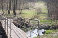 Early spring landscape with a small wild river, bare trees, reflections in the water, dry grass on the banks of the Royalty Free Stock Photo