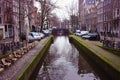 Early spring scene in Amsterdam city. Tours by boat on the famous Dutch canals. Cityscape with canal houses in Holland, Royalty Free Stock Photo