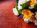 Early spring small flowers bouquet on scratched wooden surface, snowdrop, lilly, green leaves