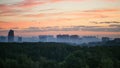 Early sunrise and morning mist over woods and city Royalty Free Stock Photo
