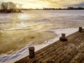 Early sunrise over frozen lake from pier Royalty Free Stock Photo