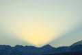 Early sunrise in the Trans-Ili Alatau mountains, the sun's rays pass over the mountains in the early winter morning