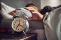 Early to bed, early to rise. a young man reaching for his alarm clock after waking up in bed at home. Royalty Free Stock Photo