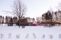 Early winter sunset view of small red barn in field with mixed trees covered in fresh snow Royalty Free Stock Photo