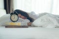 Early Work day. Close up Alarm vintage clock with women sleep the bed in morning. Royalty Free Stock Photo