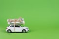 Earn cash with your car concept. Side profile full photo picture of small white car with rolls piles of usd money on top isolated Royalty Free Stock Photo