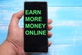 Earn more money online, text words typography written on smart phone against blue background, life and business motivational