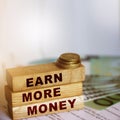 Earn More Money on wooden blocks, coins and bills. Business and career concept