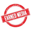 EARNED MEDIA text on red grungy round stamp