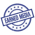 EARNED MEDIA text written on blue vintage round stamp