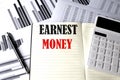 EARNEST MONEY text written on a notebook on chart and diagram Royalty Free Stock Photo