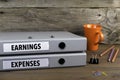 Earnings and Expenses - two folders on wooden office desk Royalty Free Stock Photo