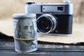 Earnings in photography, a camera and money dollars are on the table