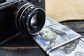 Earnings in photography, a camera and money dollars are on the table