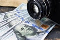 Earnings in photography, a camera and money dollars are on the table