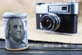 Earnings in photography, a camera and money dollars are on the table