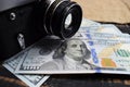 Earnings in photography, a camera and money dollars are on the table