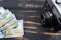 Earnings in photography, a camera and money dollars are on the table