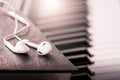 Earphone on book on piano key in vintage color tone Royalty Free Stock Photo