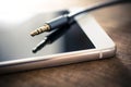 Earphone Cable Plugged Out, Lying On White Smartphone On Wooden Table Royalty Free Stock Photo