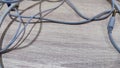 Tangling earphone and charging cable on wooden background