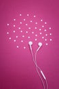 Earphones and hearts on bright magenta background