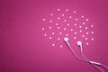 Earphones and hearts on vibrant purple background