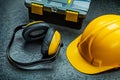 Earphones helmet and tool box on black background Royalty Free Stock Photo